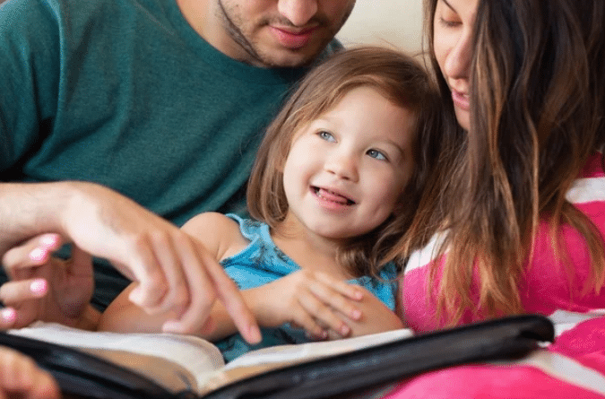 a child smiling while learning with parents