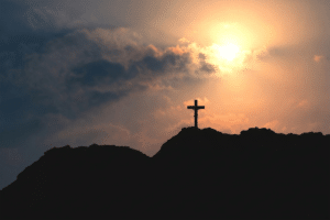 cross on a hill at sunset representing good friday and the crucifixion of jesus