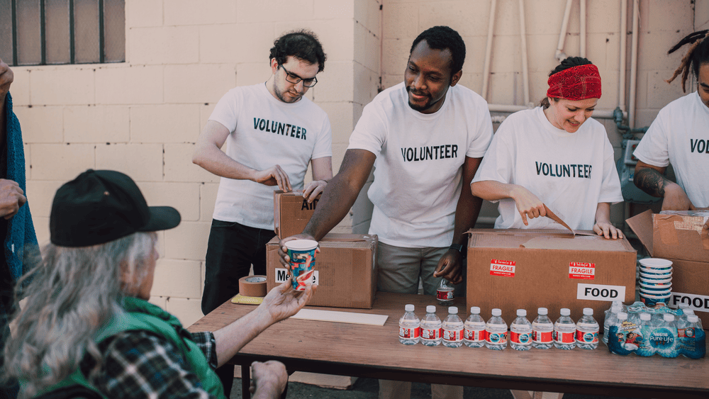 Volunteers organizing food boxes for donation, highlighting the importance of giving and community impact